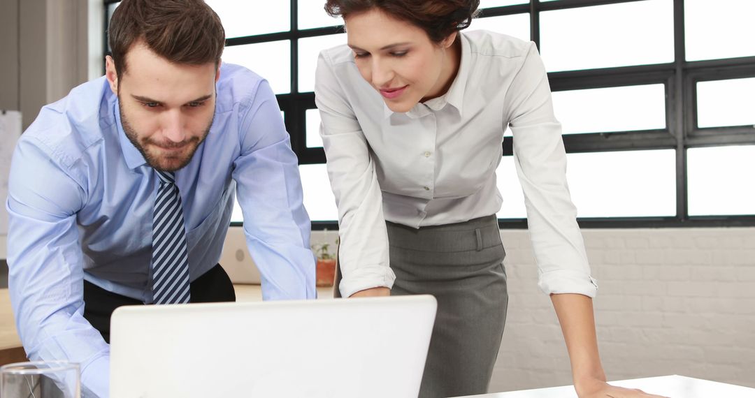 Male and Female Professionals Collaborating on Laptop in Modern Office - Free Images, Stock Photos and Pictures on Pikwizard.com