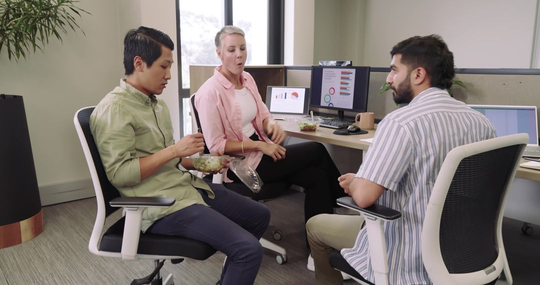 Diverse Team Engaging in Leisurely Conversation During Office Lunch Break