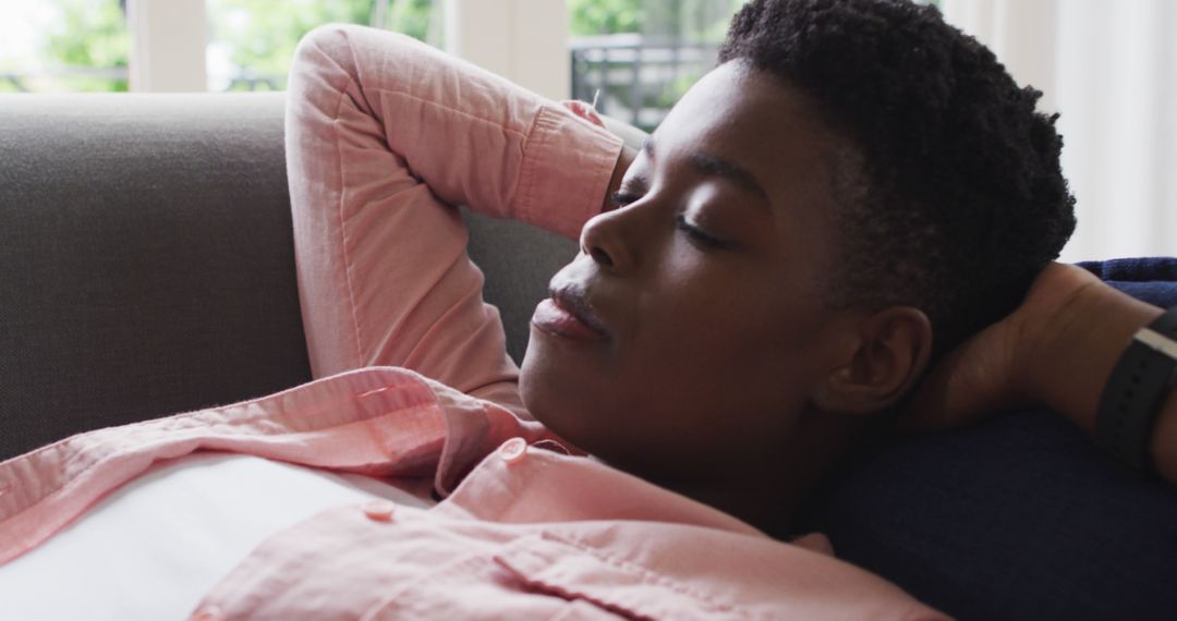 Relaxed African American Woman Napping on Home Couch During Daytime - Free Images, Stock Photos and Pictures on Pikwizard.com