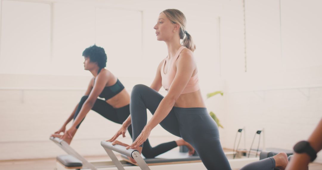 Women Exercising Yoga on Reformers in Studio Environment