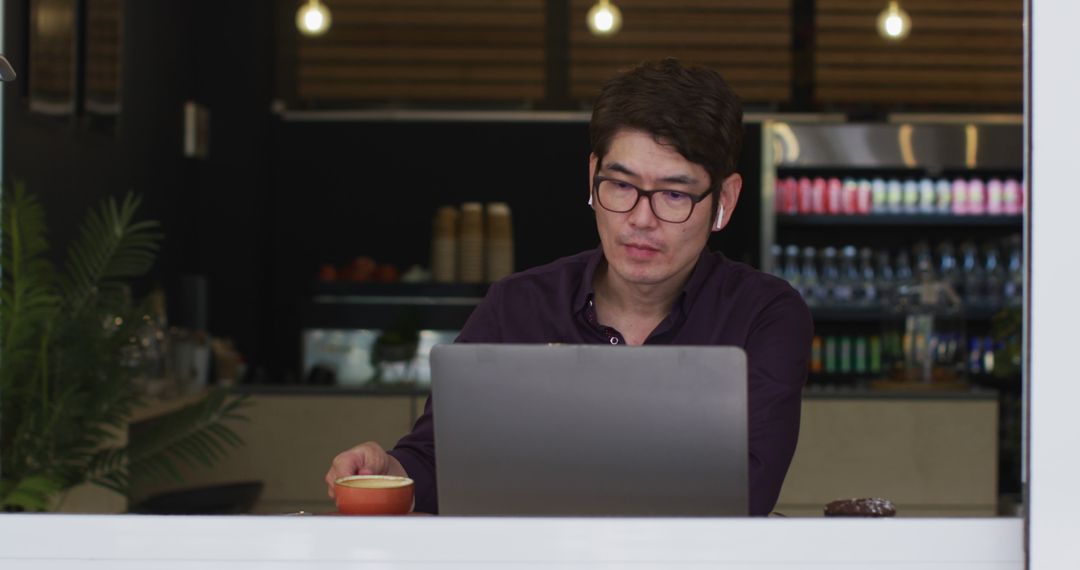Businessman Using Laptop While Relaxing in Cafe