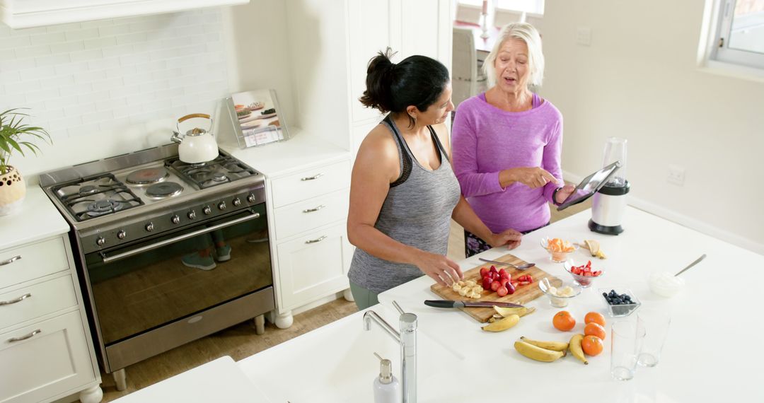 Senior woman and young woman preparing healthy food in modern kitchen - Free Images, Stock Photos and Pictures on Pikwizard.com