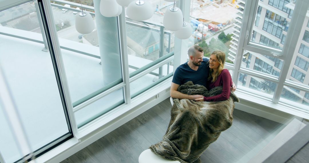 Couple Relaxing Indoors in Modern High-Rise Apartment - Free Images, Stock Photos and Pictures on Pikwizard.com