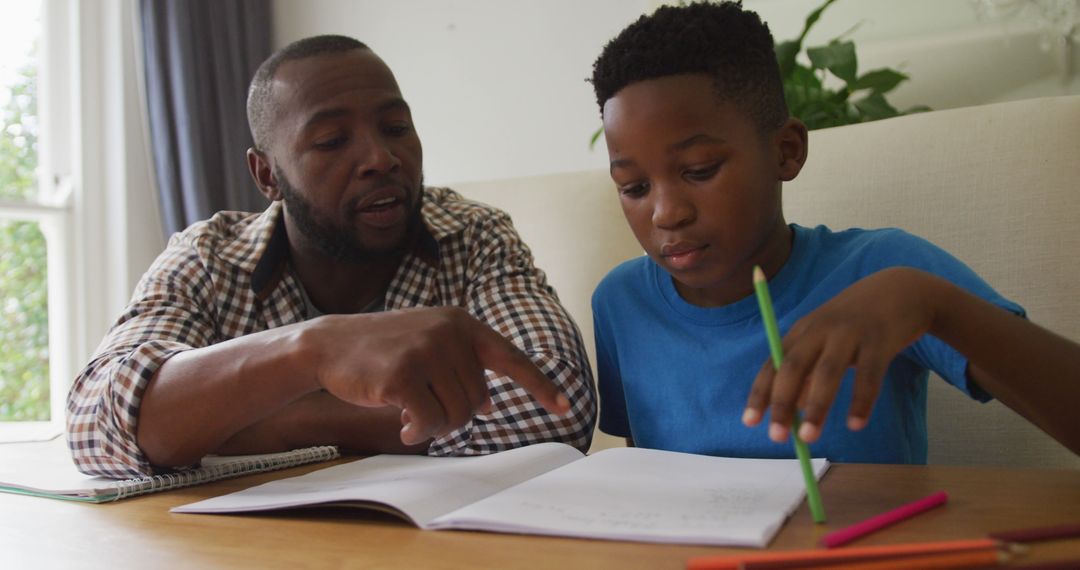 Happy African American Father Assisting Son with Homework at Kitchen Table - Free Images, Stock Photos and Pictures on Pikwizard.com