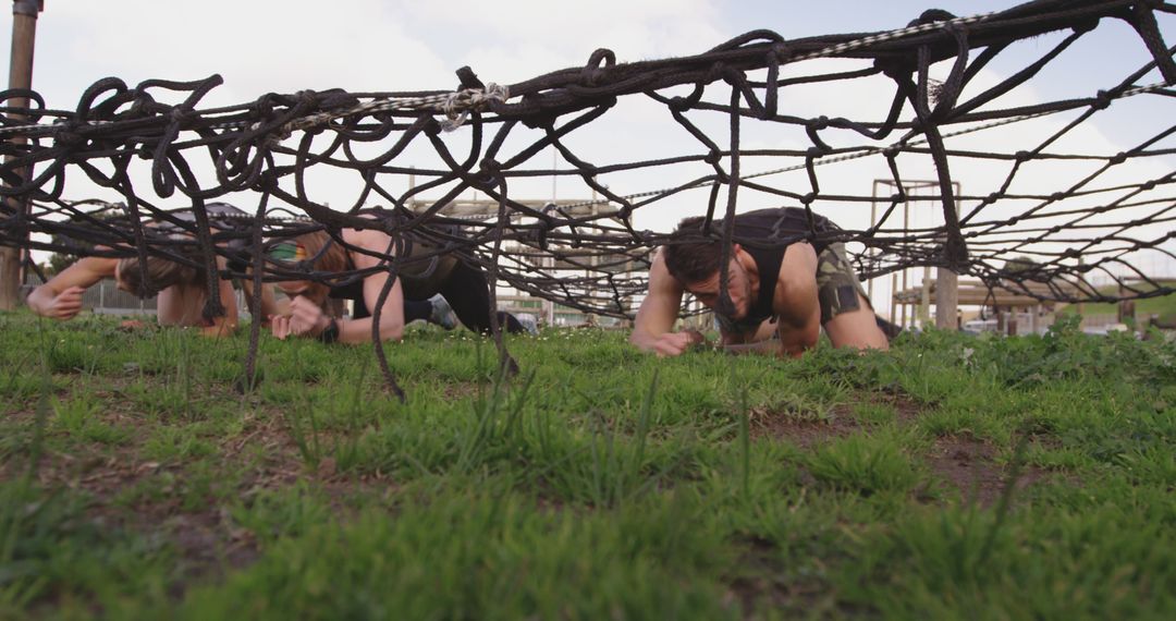 Participants Crawling Under Net During Obstacle Course Race - Free Images, Stock Photos and Pictures on Pikwizard.com