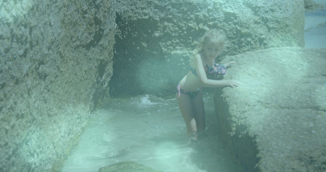 Child Exploring Rocky Shores in Sunny Beach Setting