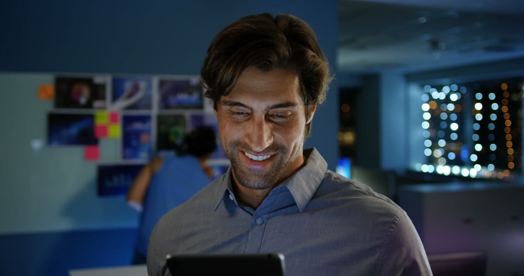 Happy Male Executive Using Digital Tablet in Modern Office at Night
