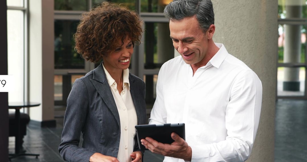 Business Professionals Collaborating on Tablet in Office Lobby