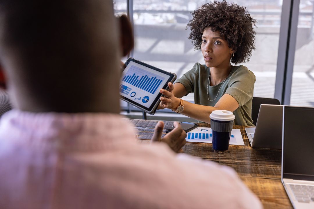 Business Professionals Discuss Analytics with Tablet Presentation