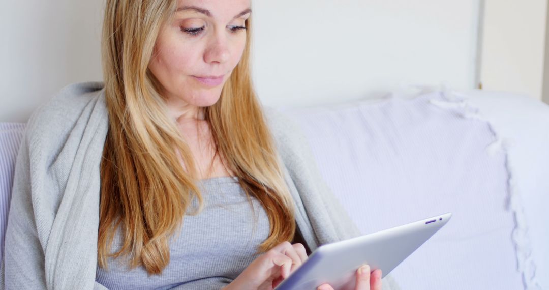 Woman Engaging with Tablet from Comfortable Couch - Free Images, Stock Photos and Pictures on Pikwizard.com