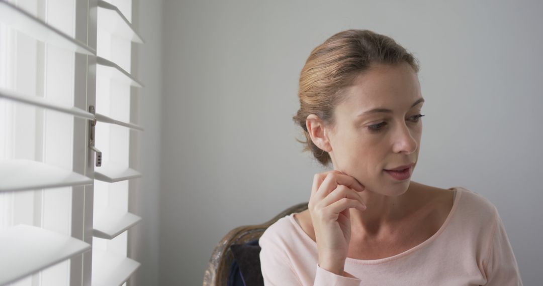 Pensive Woman Contemplating by Window with Blinds - Free Images, Stock Photos and Pictures on Pikwizard.com