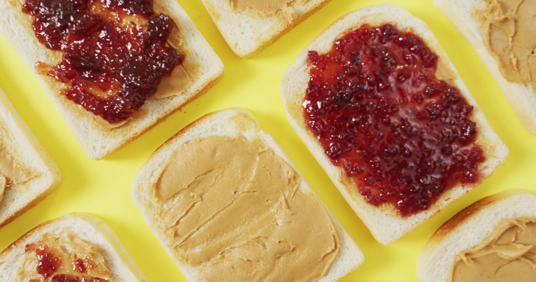 Close up of multiple peanut butter and jelly sandwiches on yellow surface - Free Images, Stock Photos and Pictures on Pikwizard.com