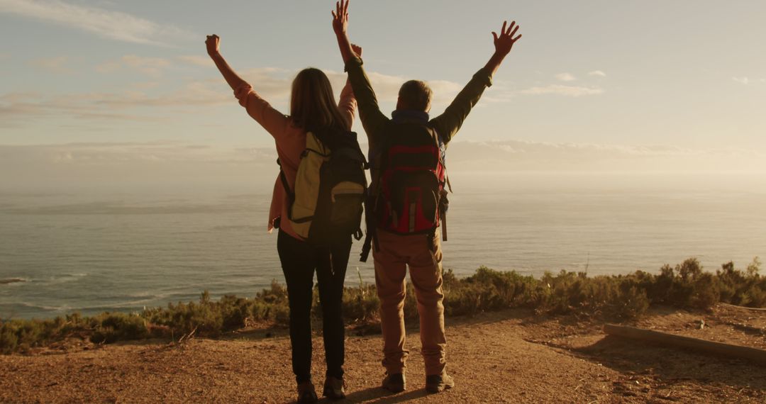 Happy Hikers Celebrating Success with Breathtaking Ocean View - Free Images, Stock Photos and Pictures on Pikwizard.com