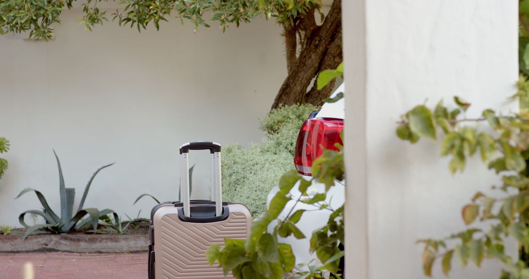 Stylish Carry-On Suitcase beside Elegant Stucco Architecture