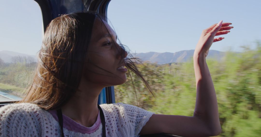 Woman Enjoys Scenic View from Moving Vehicle on Sunny Day - Free Images, Stock Photos and Pictures on Pikwizard.com