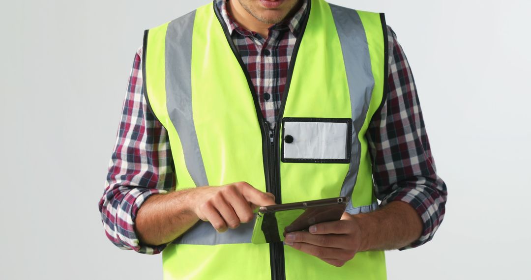 Construction Worker in Safety Vest Using Tablet for Inspection - Free Images, Stock Photos and Pictures on Pikwizard.com