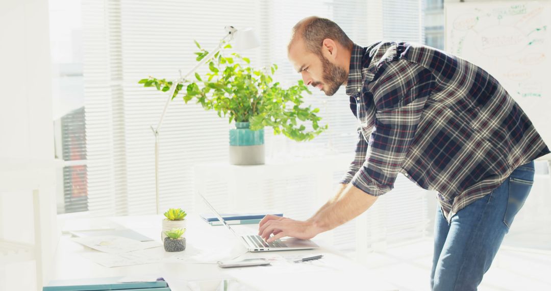 Man Working on Laptop in Bright Modern Office - Free Images, Stock Photos and Pictures on Pikwizard.com