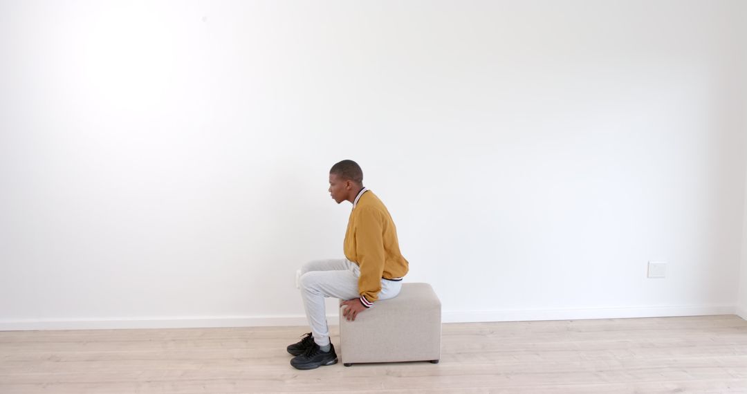 Man Practicing Balance on Stool in Minimalist Room