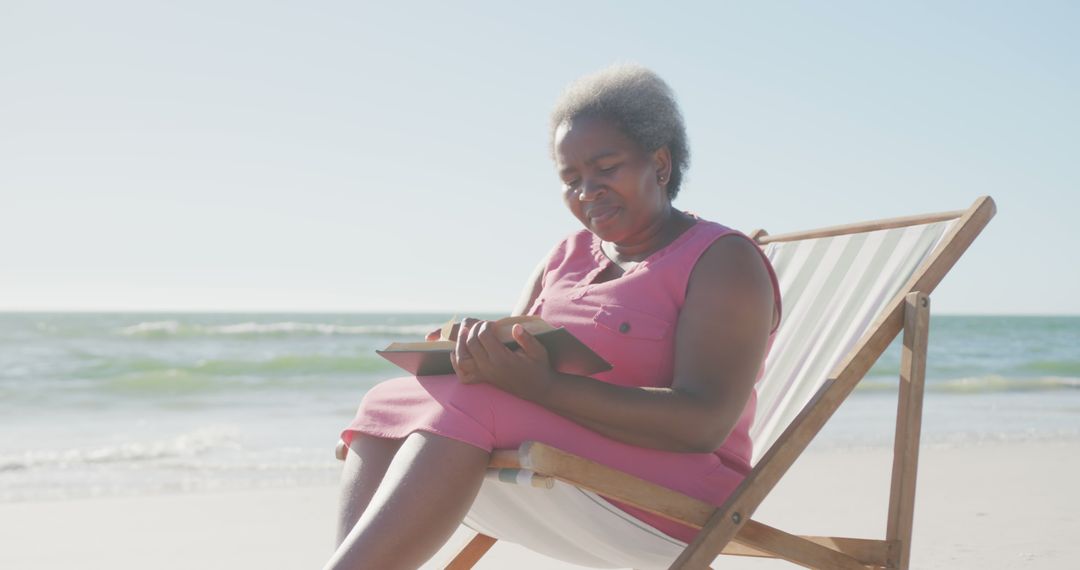 Senior Woman Relaxing at Beach Reading Tablet - Free Images, Stock Photos and Pictures on Pikwizard.com