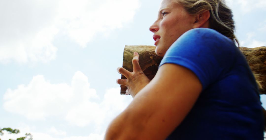 Woman Carrying Wooden Log Over Shoulder in Bright Daylight - Free Images, Stock Photos and Pictures on Pikwizard.com