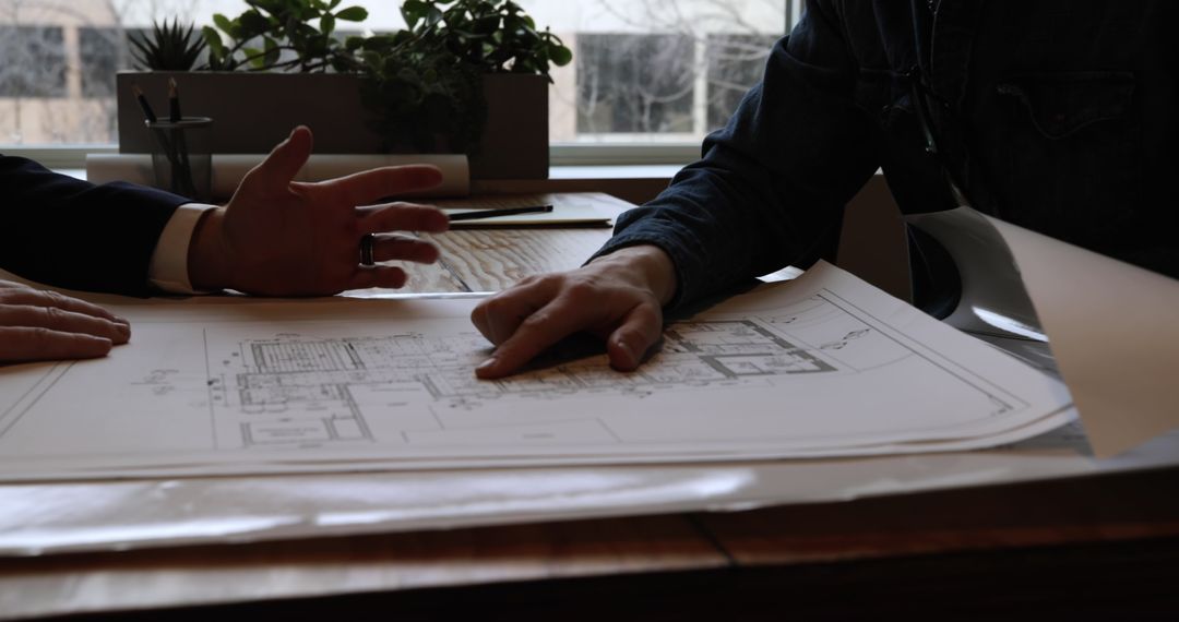 Architects Discussing Building Plans Inside Office