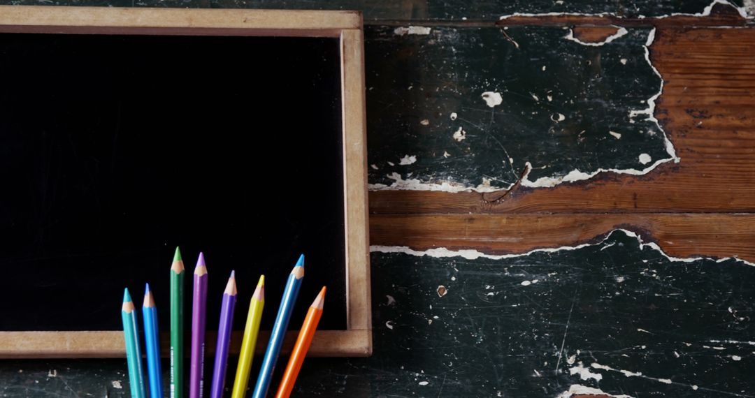 Colorful Pencils with Blank Chalkboard on Rustic Wooden Table