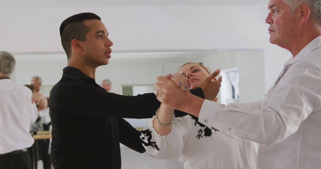 Focused Dance Teacher Instructing Senior Couple in Ballroom Class