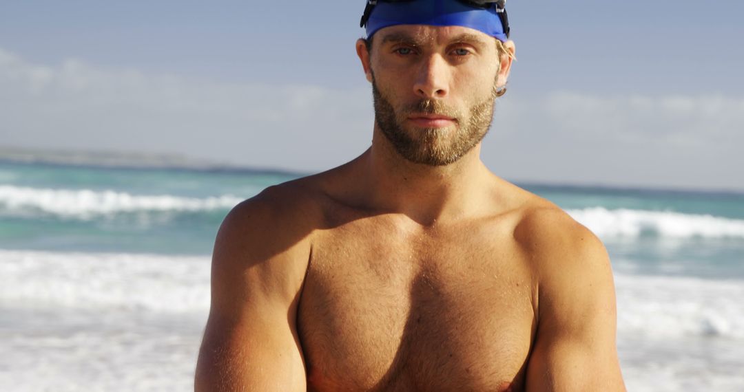 Serious Male Swimmer Standing on Beach with Ocean Background - Free Images, Stock Photos and Pictures on Pikwizard.com