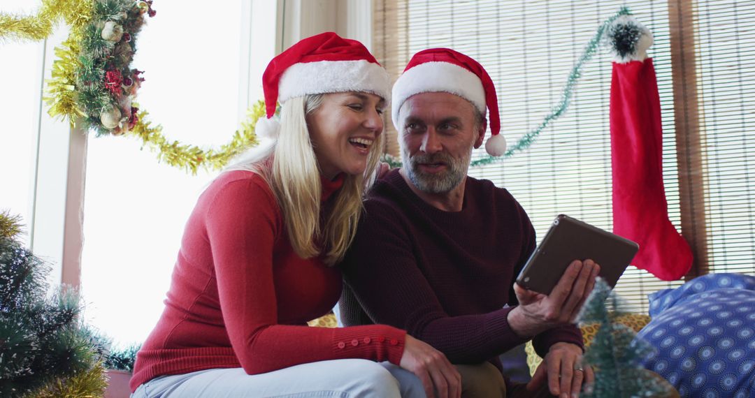 Couple Celebrating Christmas at Home with Digital Tablet - Free Images, Stock Photos and Pictures on Pikwizard.com