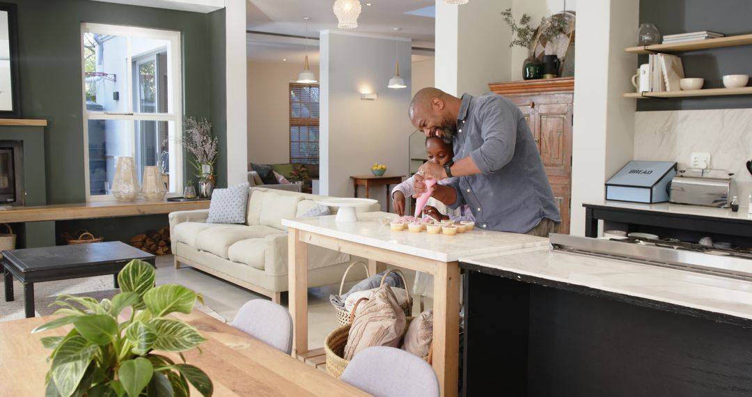 Father and Daughter Baking and Decorating Cupcakes in Home Kitchen