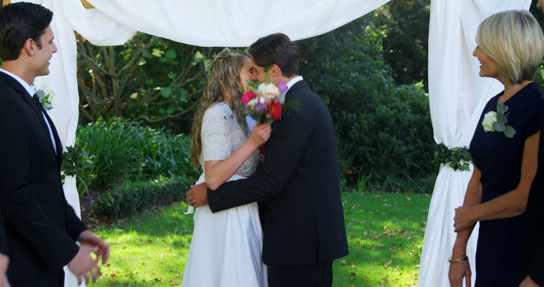 Bride and Groom Sharing First Kiss at Outdoor Wedding Ceremony - Free Images, Stock Photos and Pictures on Pikwizard.com