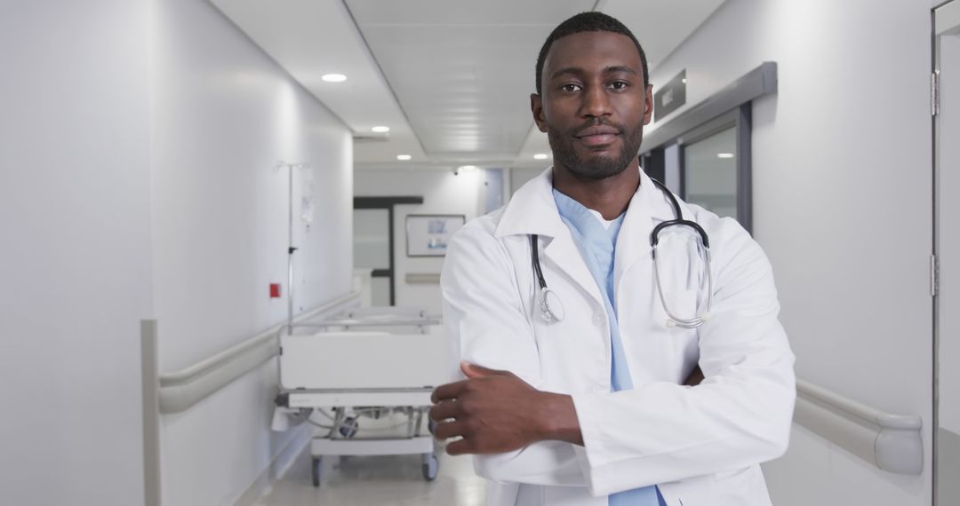 Confident African American doctor standing in hospital corridor with crossed arms - Free Images, Stock Photos and Pictures on Pikwizard.com