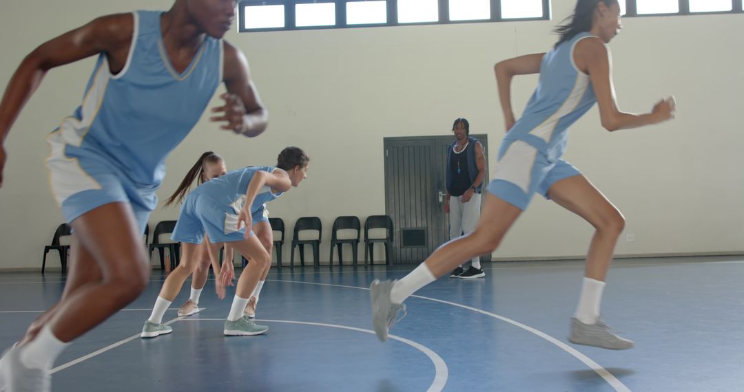 Female Basketball Team Sprinting during Training with Coach