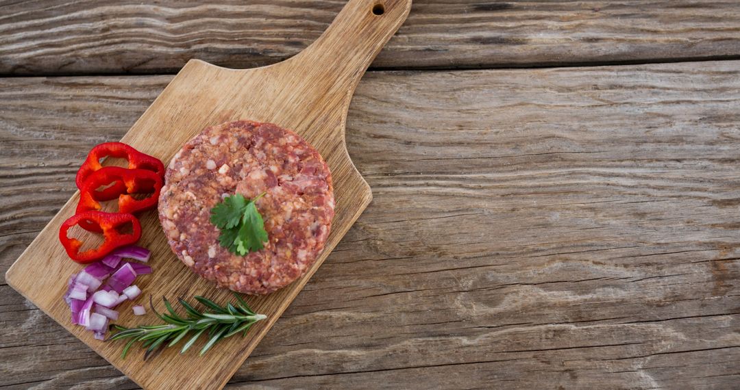 Rustic Culinary Preparation with Raw Beef Burger Patty and Fresh Vegetables