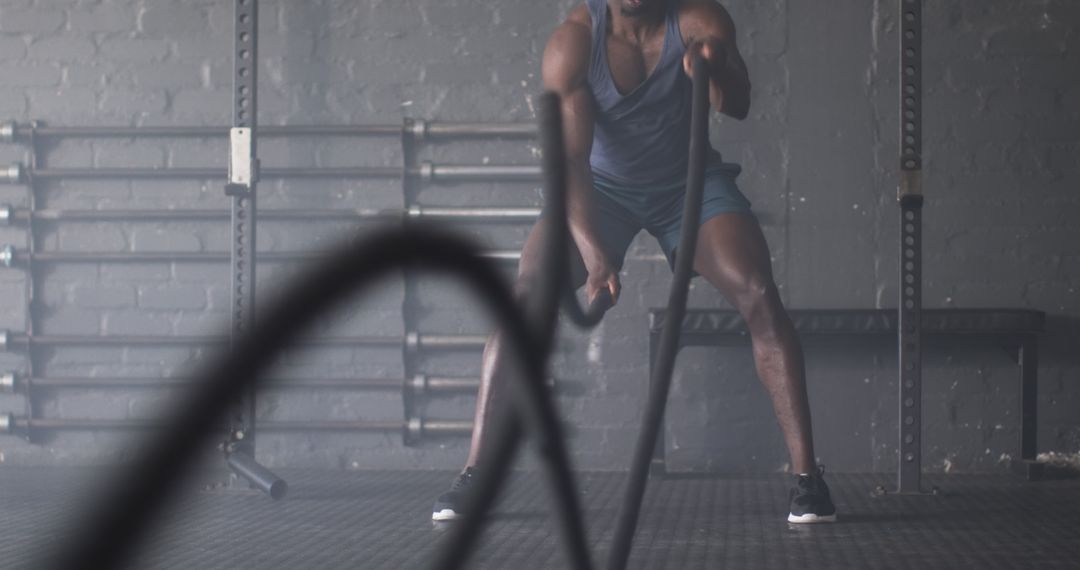 Man Engaging with Battle Ropes for Intense Workout