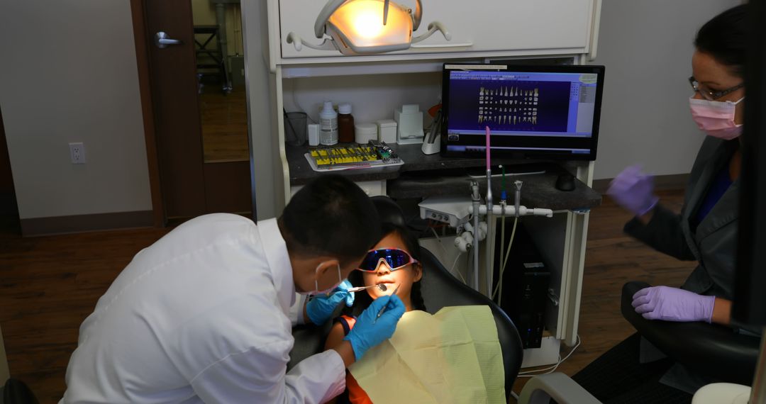 Dentist Examining Teeth of Child Patient with Parents Nearby - Free Images, Stock Photos and Pictures on Pikwizard.com