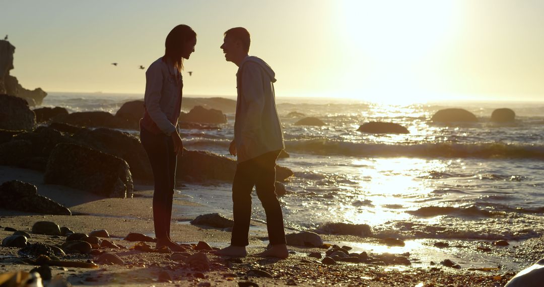 A young Caucasian couple enjoys a romantic moment on the beach at sunset, with copy space - Free Images, Stock Photos and Pictures on Pikwizard.com