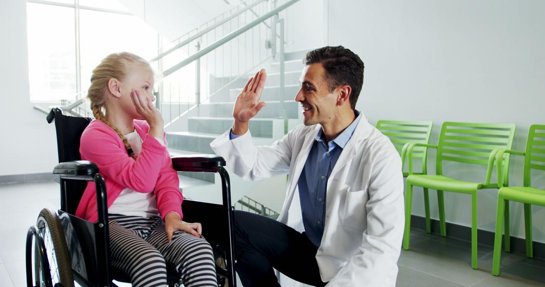 Doctor Encouraging Young Girl in Wheelchair with High Five in Hospital - Free Images, Stock Photos and Pictures on Pikwizard.com