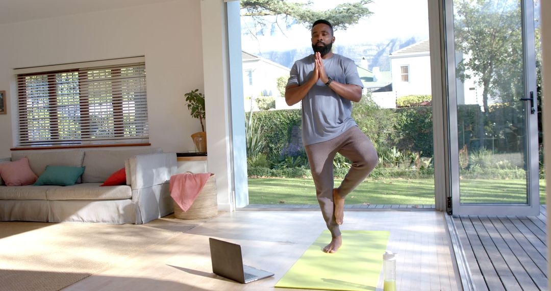 Man Practicing Yoga with Laptop in Bright Living Room - Free Images, Stock Photos and Pictures on Pikwizard.com