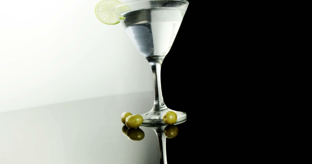 An elegant martini, garnished with lime and olives, sets the mood for upscale socializing. - Free Images, Stock Photos and Pictures on Pikwizard.com