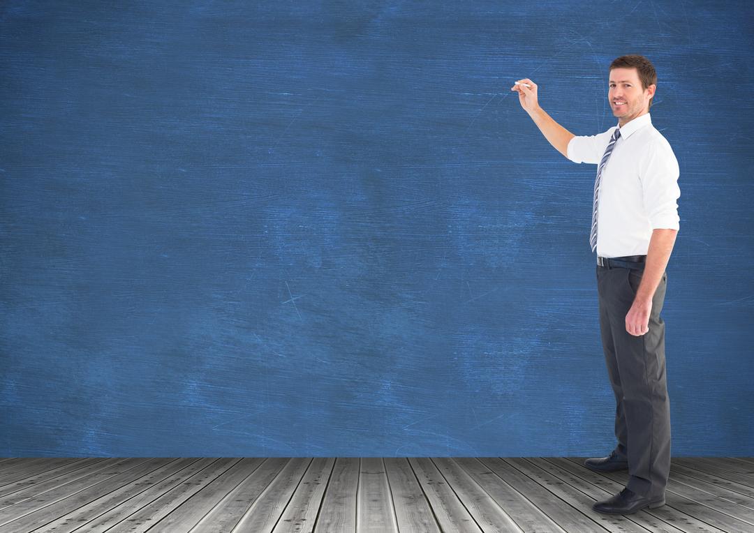 Businessman standing and holding a chalk against chalkboard in background - Free Images, Stock Photos and Pictures on Pikwizard.com