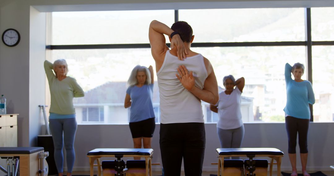 Instructor Leading Group of Seniors in Fitness Class with Stretching Exercises - Free Images, Stock Photos and Pictures on Pikwizard.com