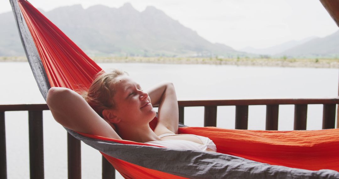 Female Reclining in Hammock by Lake with Mountain in Background - Free Images, Stock Photos and Pictures on Pikwizard.com