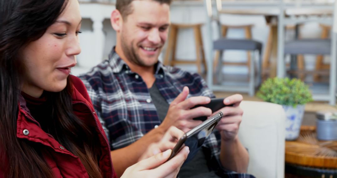 Couple Enjoying Digital Interaction at Cozy Cafe