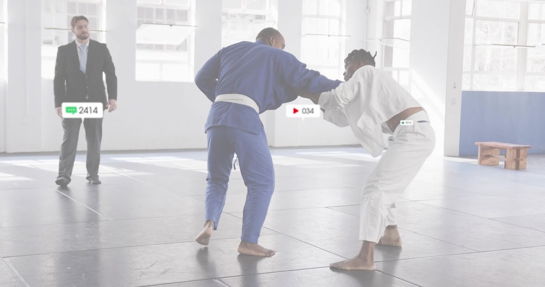 Grappling Judo Partners Sparring on Mats with Referee Observing in Bright Dojo