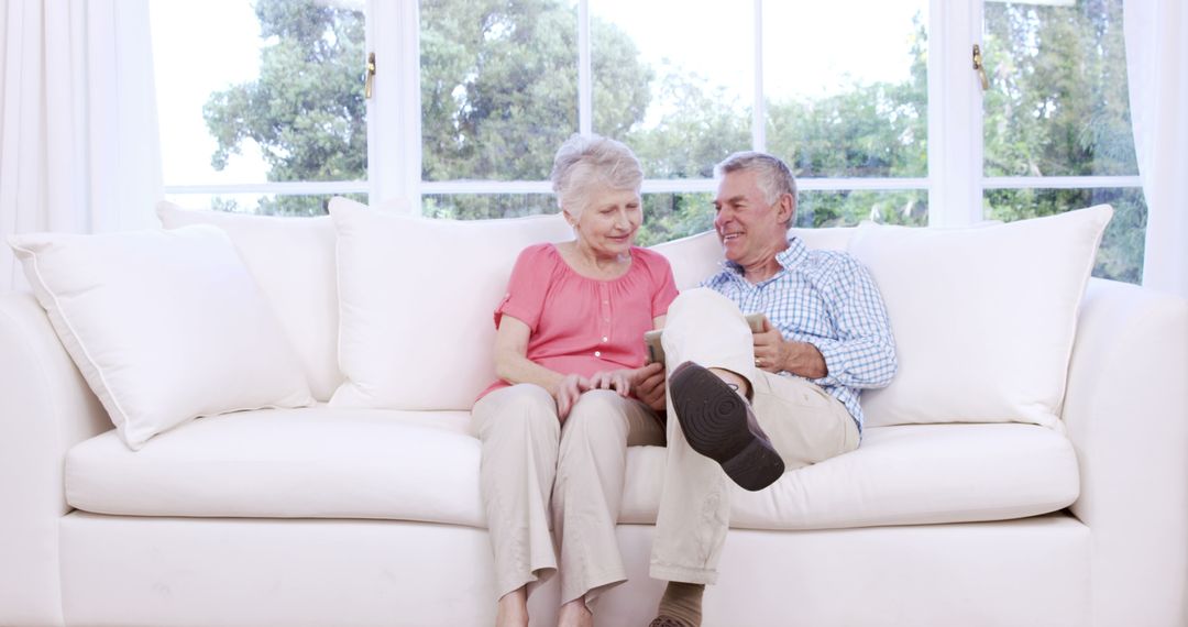 Senior Couple Relaxing on Couch at Home with Natural Light - Free Images, Stock Photos and Pictures on Pikwizard.com