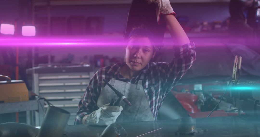 Female Welder Taking a Break at Workshop Showing Dedication and Skill