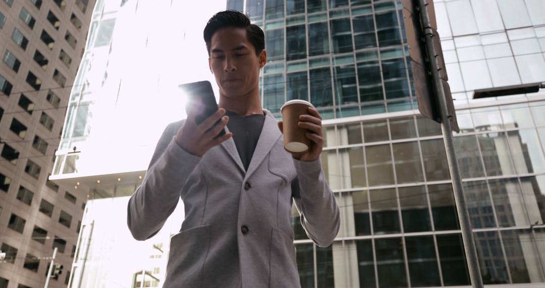 Businessman Checking Smartphone with Coffee in Modern Cityscape