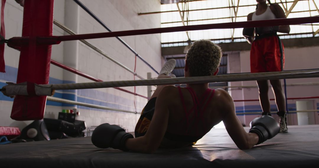 Boxer Sitting on Ring Floor After Knockdown During Training Session - Free Images, Stock Photos and Pictures on Pikwizard.com