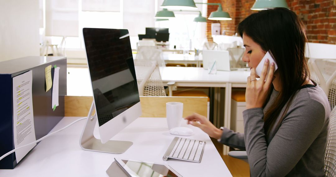 Businesswoman Multitasking in Modern Office Workspace - Free Images, Stock Photos and Pictures on Pikwizard.com